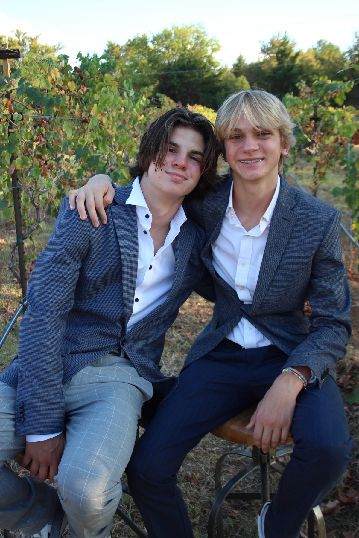 Two young men in suits photographed in the vineyard